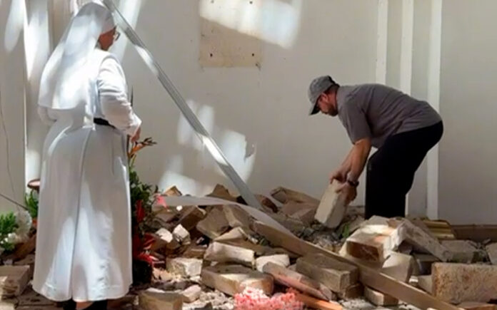Con reverencia, sacerdote y religiosa colombianos recogen hostias que el sismo esparció por el suelo
